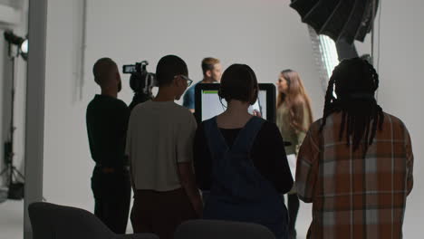 Vista-Trasera-Del-Equipo-Filmando-Una-Película-O-Un-Video-En-El-Estudio-Con-Actores,-Directora,-Camarógrafo,-Grabadora-De-Sonido-Y-Asistente